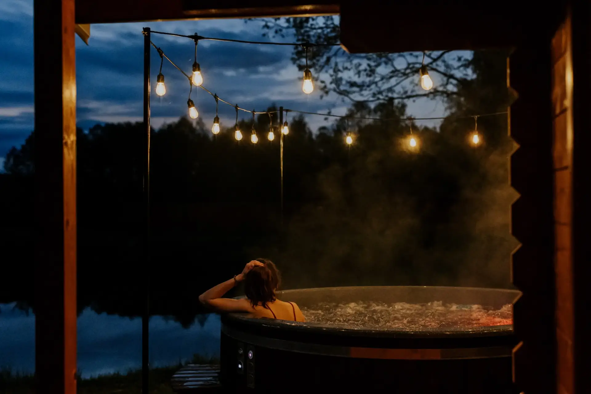 Prywatna balia z jacuzzi na tarasie domku o zmierzchu