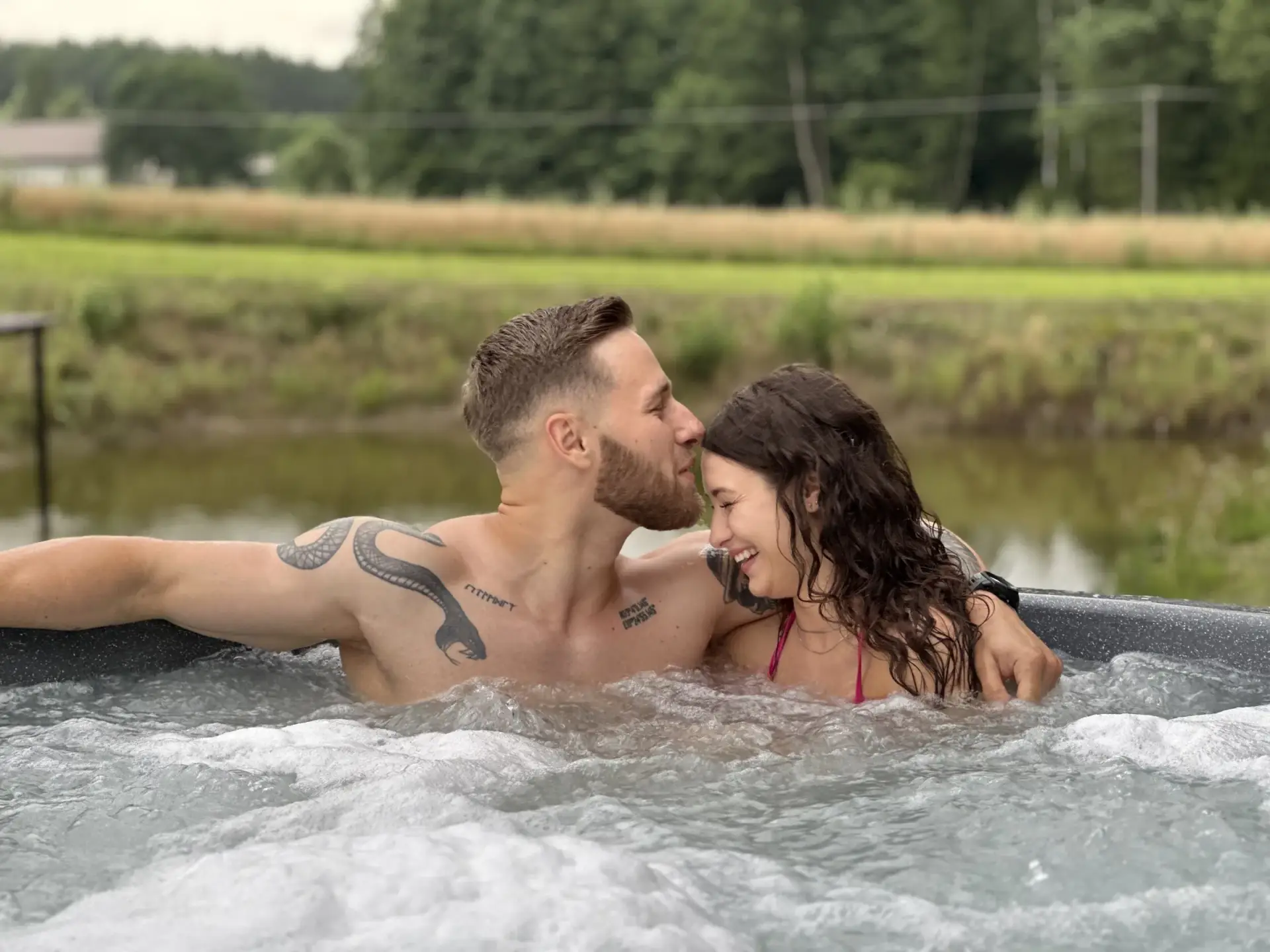 Prywatna balia z jacuzzi na tarasie domku, para w wodzie o zmierzchu