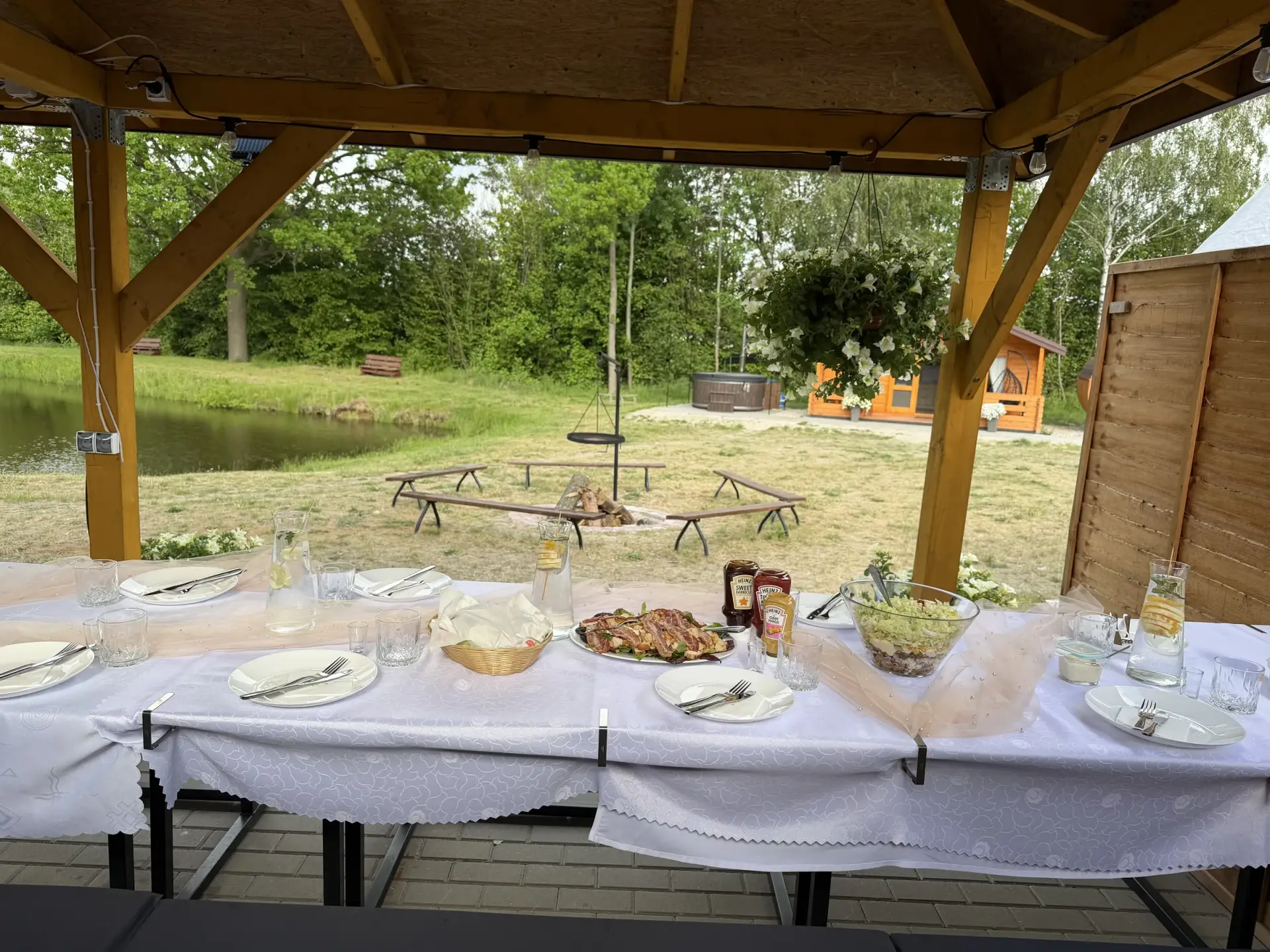 Zespół przy ognisku pod zadaszoną wiatą wieczorem na terenie rancza