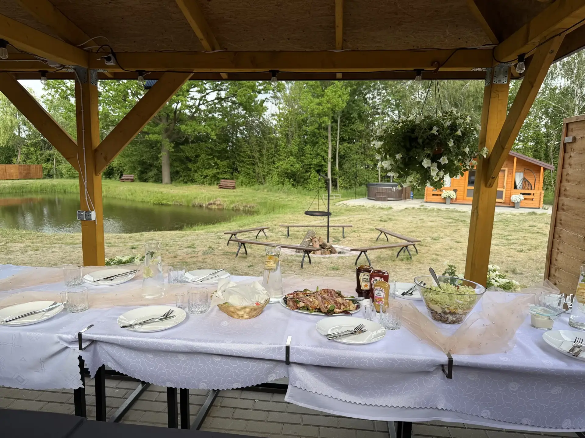 Stół imprezowy pod wiatą z widokiem na staw