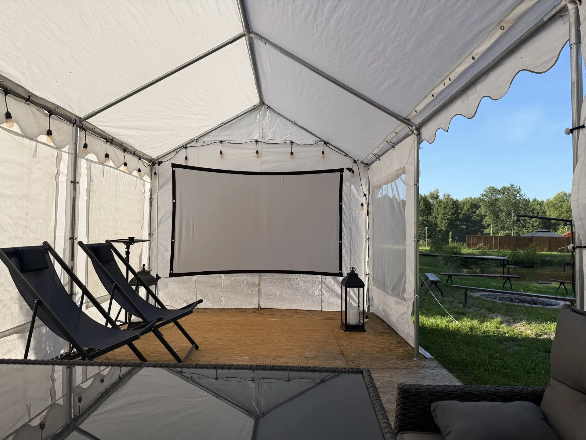 Kino plenerowe pod zadaszoną wiatą, projektor i koce wieczorem