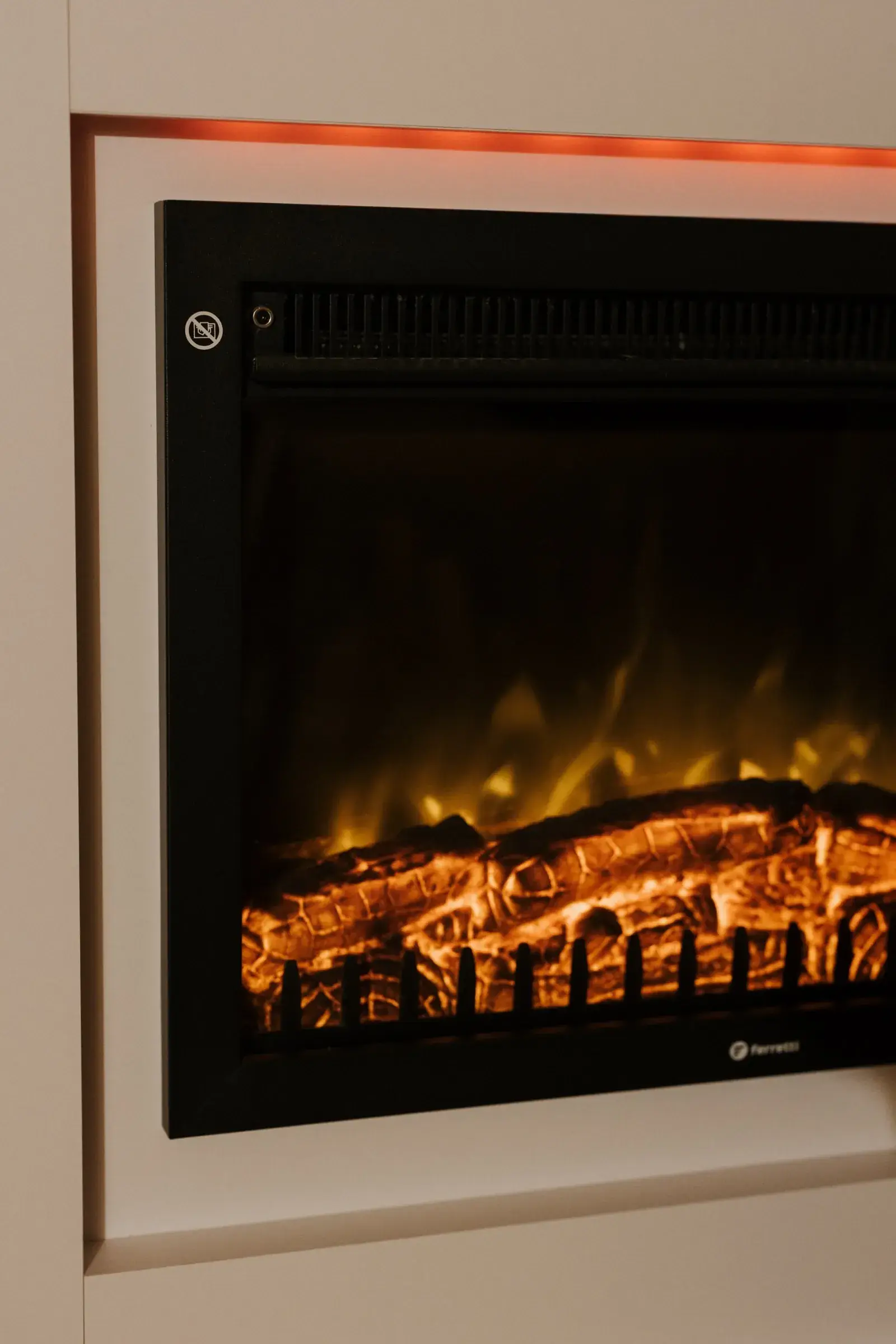 Kominek elektryczny w ścianie domku, rozpalony wieczorem