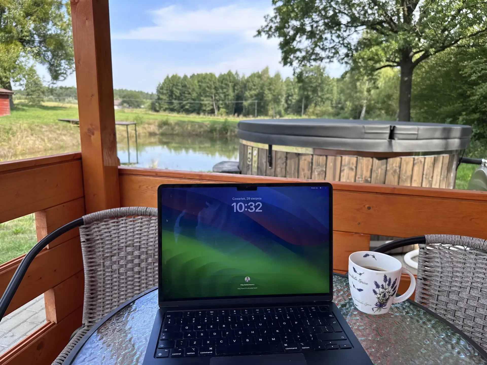 Laptop na tarasie domku, praca zdalna z widokiem na las