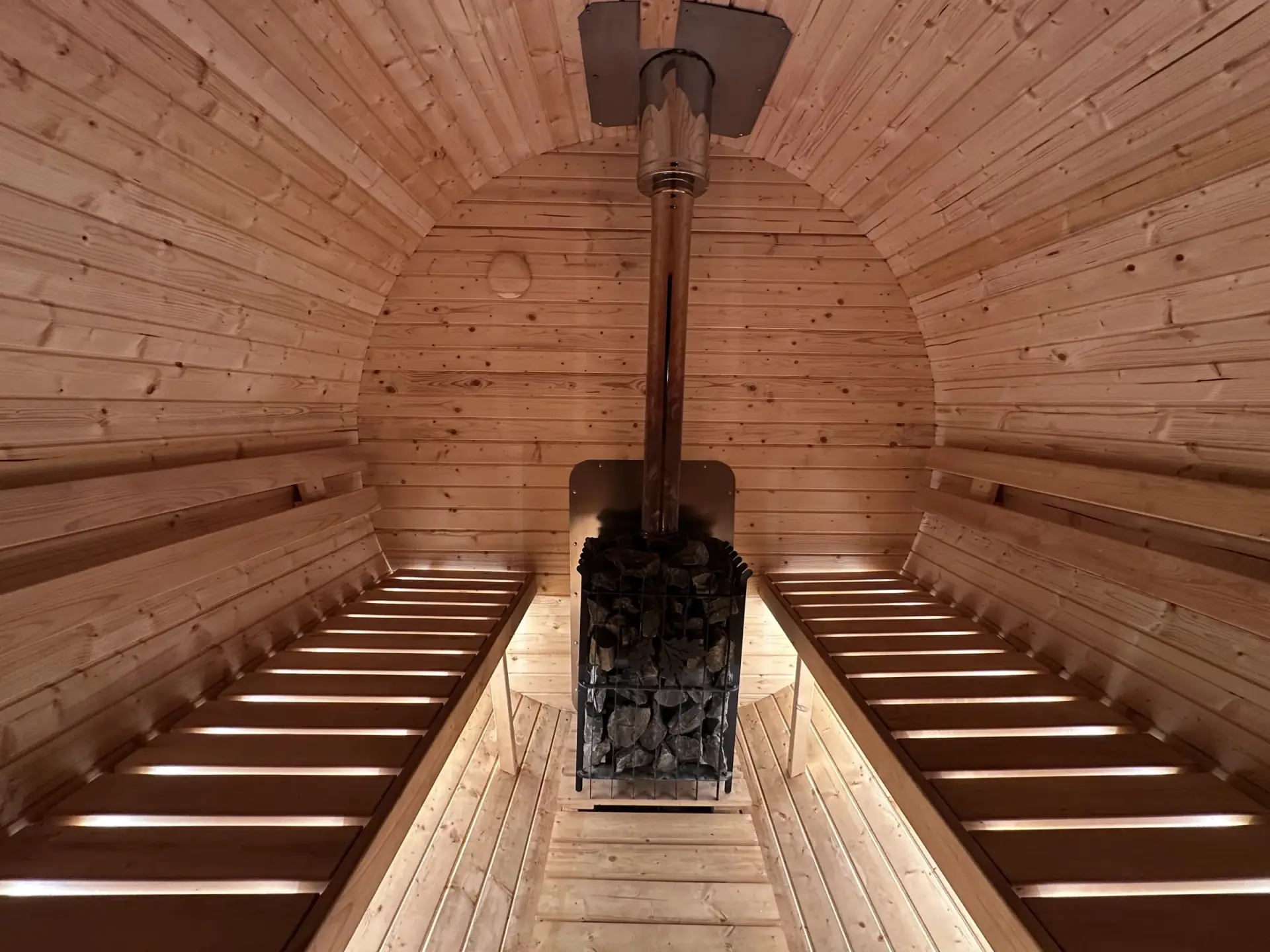 Sauna fińska przy domku, wnętrze z drewnianymi ławami